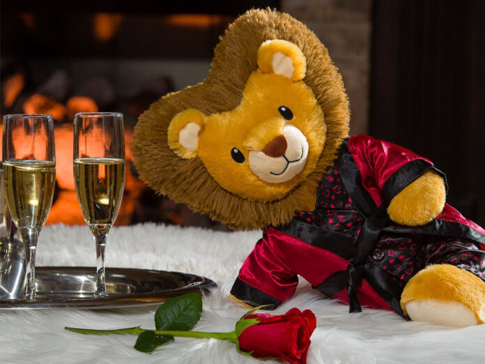 Stuffed lion posed seductively with champagne and a rose