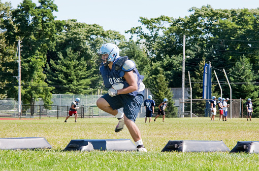 High school football player training. going through running drills