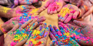 Hands holding colorful powder to celebrate Holi