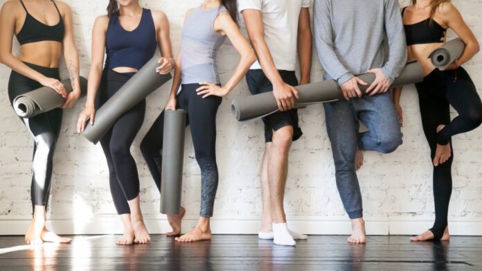 People holding exercise mats to practice yoga and pilates
