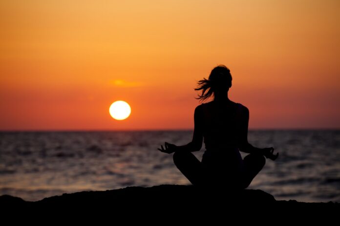 Woman meditating during the sunset