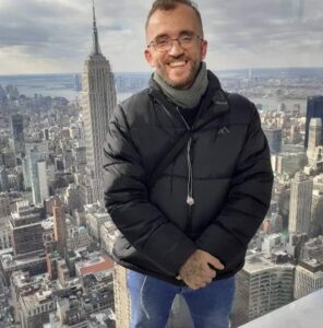 Man posing with the New York skyline in the background